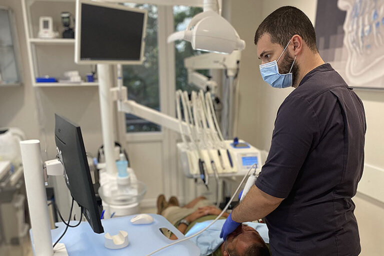 Dr. Hriczó-Koperdák Gergely intra-oral scannerrel feltérképezi a páciens fogait